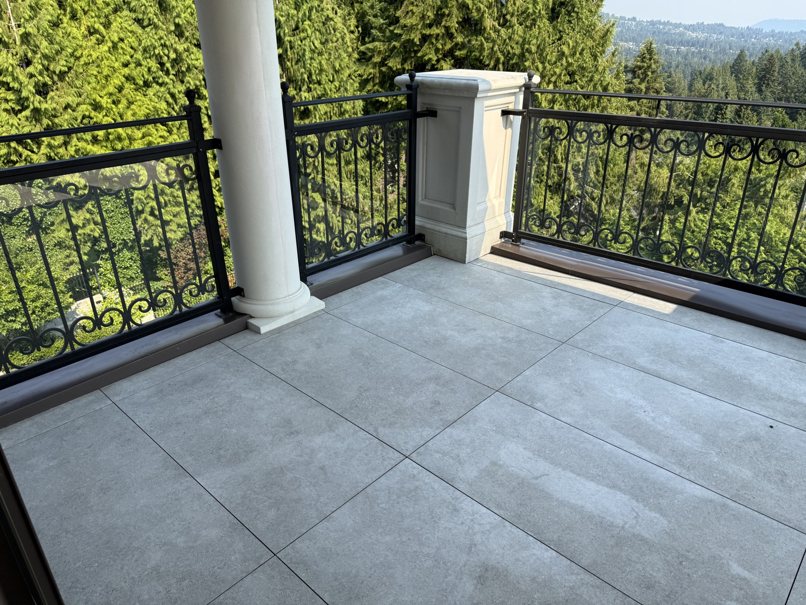 Pavers cut around an existing round column and railing posts