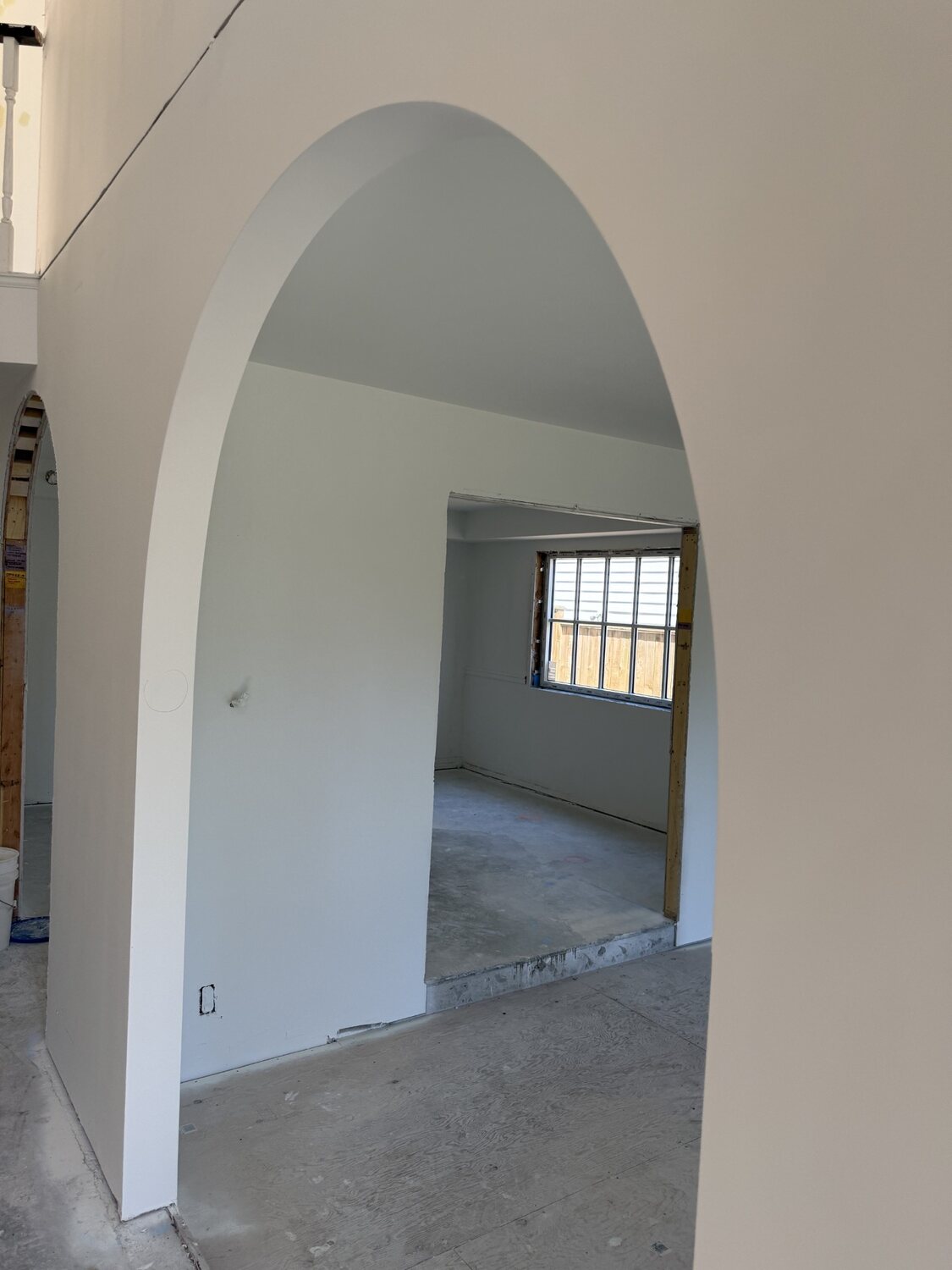 Drywall archway opening to a bright window, Viney Road renovation